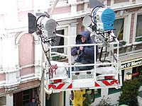 member of the film lighting team on a crane during a cold and windy day
